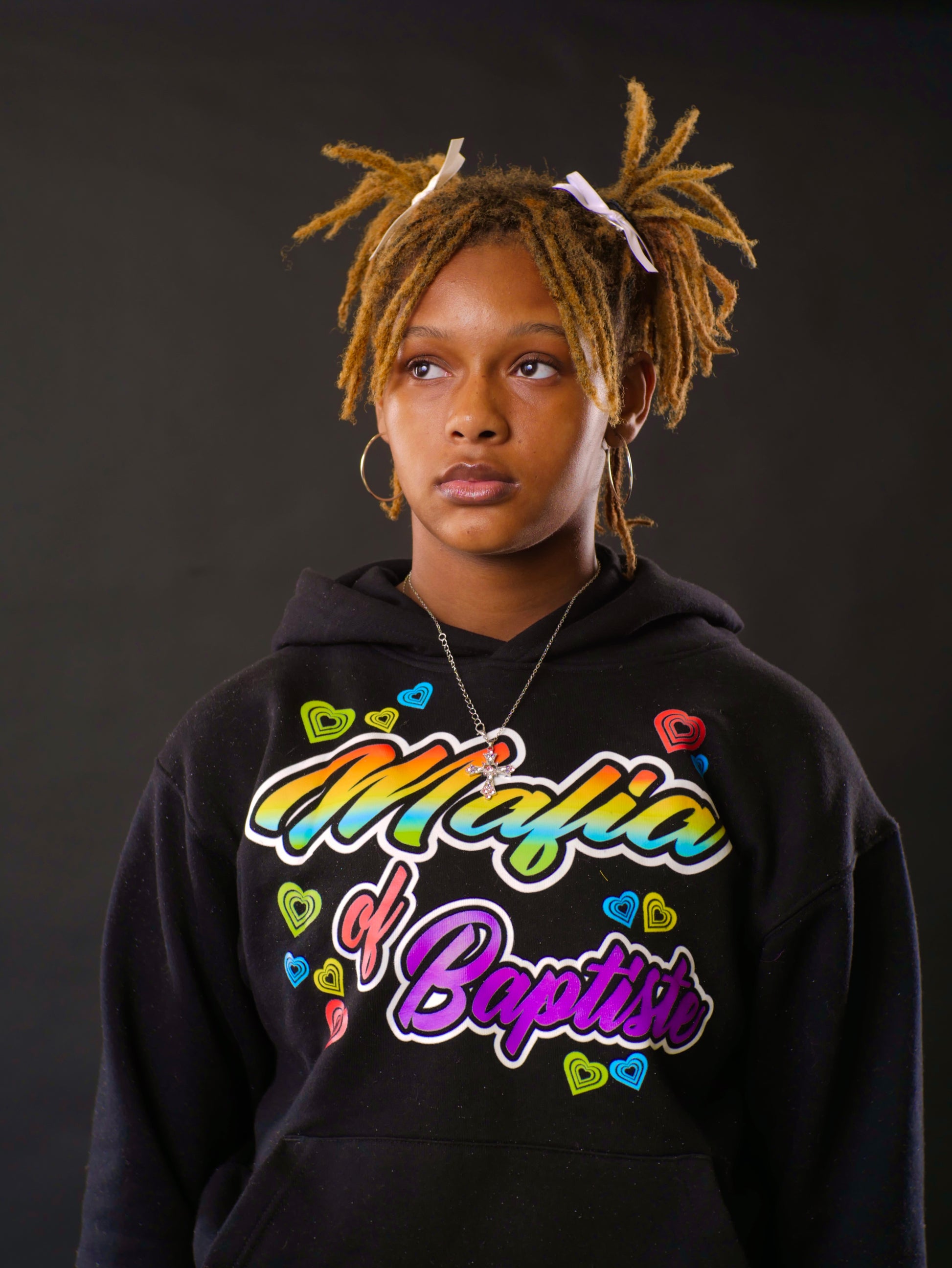 Person wearing a black hoodie with colorful text on a dark background