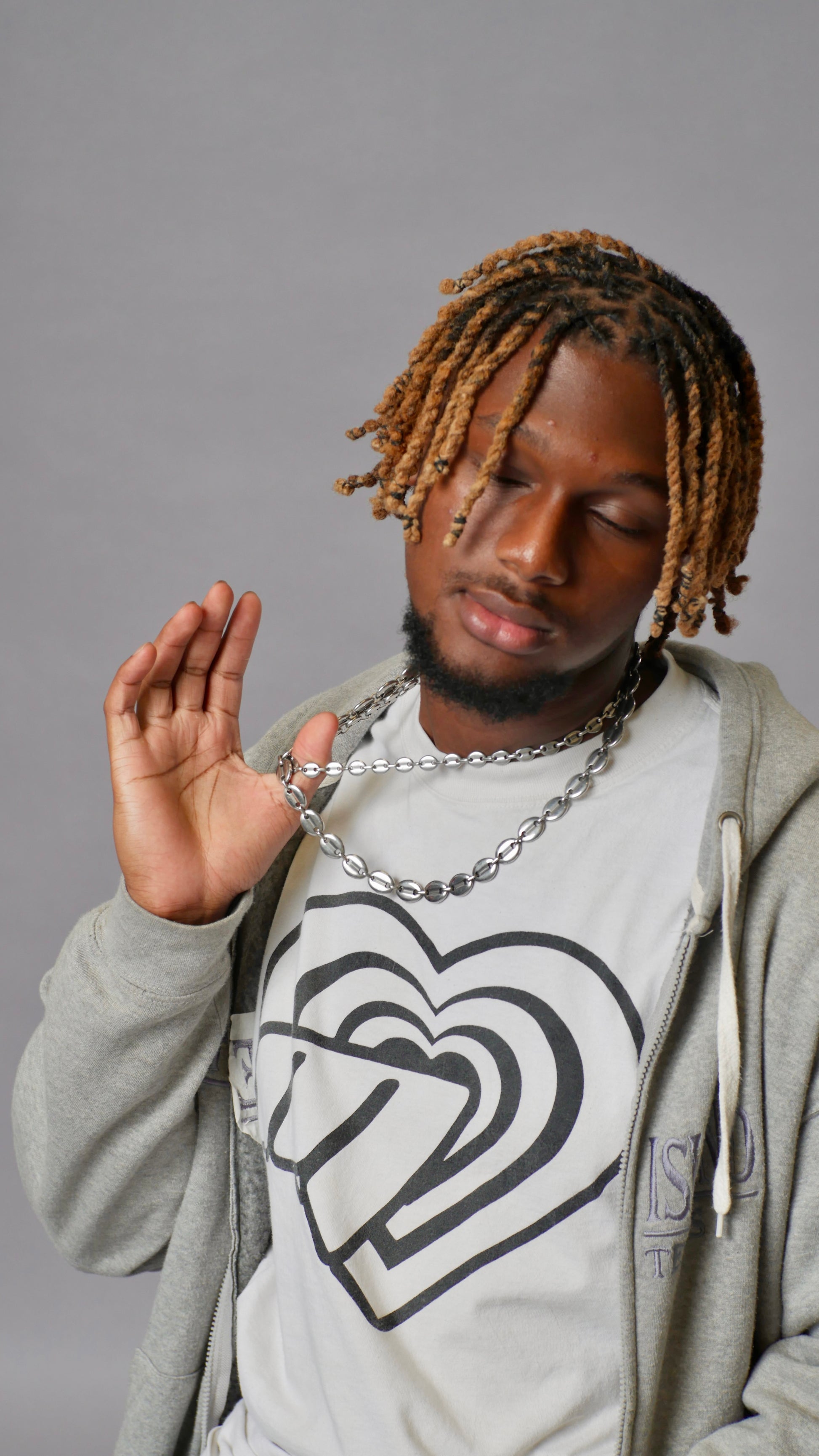 Man wearing a hoodie with a heart design on a gray background